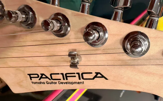 Guitar head with one poorly wrapped string.